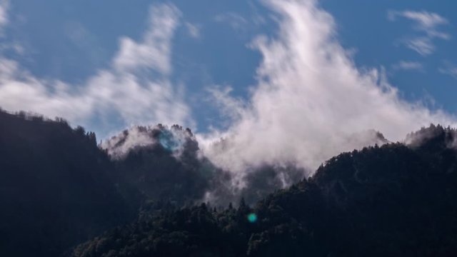 Time lapse of cloud drift over the tops of a wooded mountain range