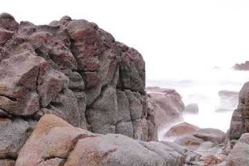RED GRANITE WALL ON THE GALICIAN COAST IN THE ATLANTIC OCEAN