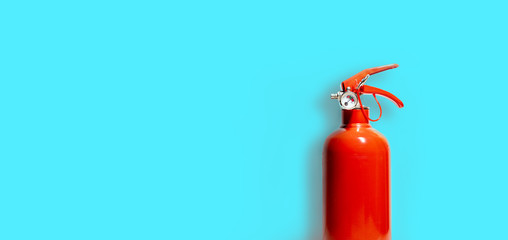 Red Fire Extinguisher and its shadow isolated on blue-green color background - Copy space - Business Concept