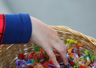 Hand taking candy from a basket