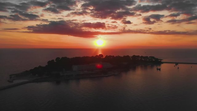 Aerial reveal shot island with sea, ocean at sunset, beautiful golden light, 4K.