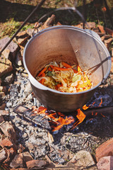 Cooking outdoors in cast iron cauldron on a campfire