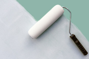 paint roller paints the wall white