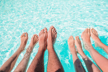 Close up of four people's legs by pool side