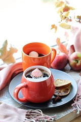Two cups of coffee, meringues, pumpkins, apples, leaves, plaid on the background of the window, home comfort concept, Thanksgiving, autumn season