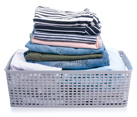 Basket with stack folded laundry clothing on white background isolation
