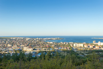 Scenic view of Gelendzhik city and sea bay. Sunrise time. Trees on hills on foreground. Vacation on resort.