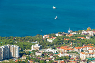 Scenic view of Gelendzhik city district and sea bay. Sunny day. Buildings, coast, ships in Black sea and horizon in frame.