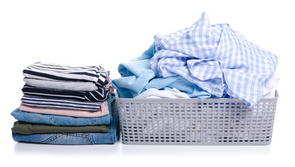 Basket with folded laundry and stack folded clothing on white background isolation