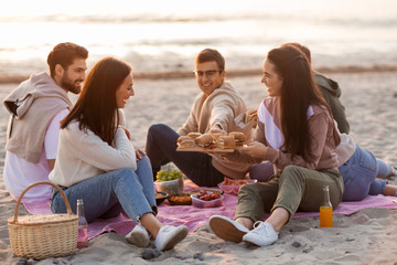 friendship, leisure and fast food concept - group of happy friends eating sandwiches or burgers at...