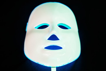 Light rejuvenating mask for facial skin therapy on black background.