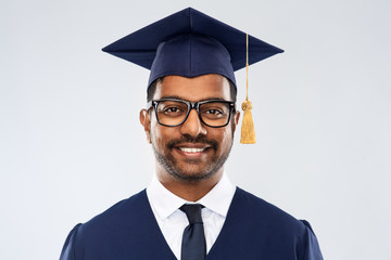 education, graduation and people concept - happy smiling indian male graduate student in mortar...