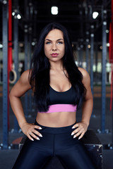 Fototapeta na wymiar Portrait of beautiful fitness woman, with black hair, posing in sexy sportswear. Gym lifestyle.