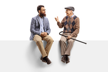 Bearded man and a senior sitting on a panel and talking