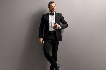 Elegant young man in a black suit and bow tie