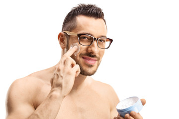 Young man putting face cream