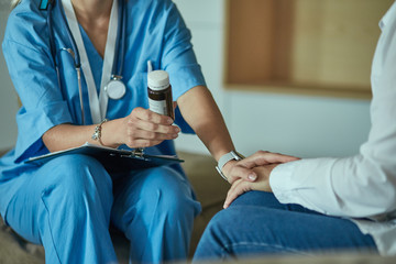 Beautiful smiling woman the doctor in a bottle of pill offers t