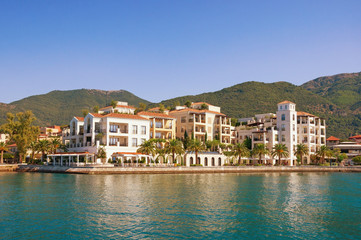 Fototapeta na wymiar Beautiful view of embankment of Tivat city from sea on sunny day. Montenegro, Adriatic Sea, Kotor Bay