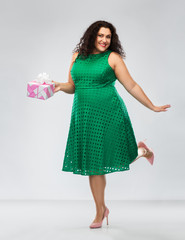 holidays, presents and people concept - happy woman in green dress holding gift box over grey background