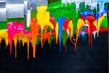 several dripping colors ink on handle printers in tee shirt factory hang on the storage