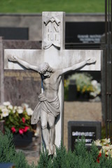 Steinkruzifix auf einem katholischen Friedhof in Österreich, Gräber in Österreich