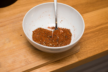 Gewürzmischung mit Löffel in einer weißen Schale