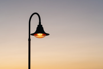 Lampposts lit at sunset