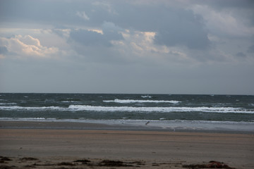 Wolkenhimmel über Strand an der Nordsee mit Dünen im Hintergrund