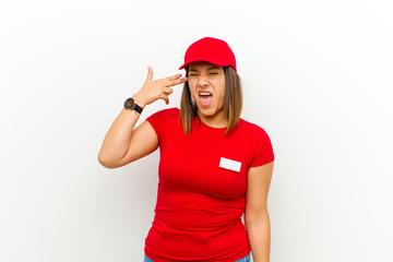 delivery woman looking unhappy and stressed, suicide gesture making gun sign with hand, pointing to...