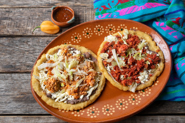Mexican food: sopes of Chorizo and beef picadillo with cheese and beans
