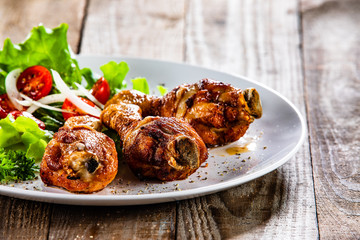 Grilled chicken drumsticks and vegetables on white plate