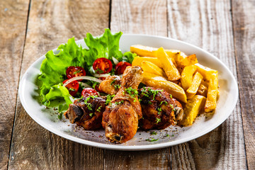 Grilled chicken drumsticks with french fries and vegetables