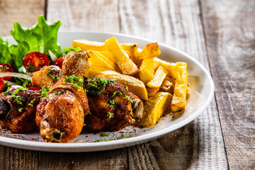 Grilled chicken drumsticks with french fries and vegetables