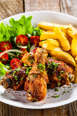 Grilled chicken drumsticks with french fries and vegetables
