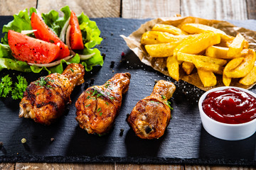 Grilled chicken drumsticks with french fries and vegetables