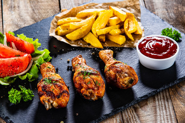 Grilled chicken drumsticks with french fries and vegetables