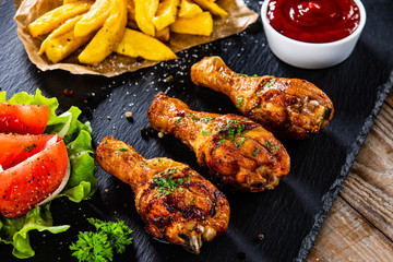 Grilled chicken drumsticks with french fries and vegetables