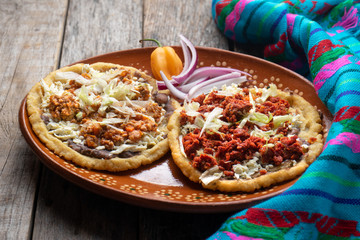 Mexican food: sopes of Chorizo and beef picadillo with cheese and beans