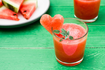 Fresh watermelon blended drink with mint leaves and a heart of watermelon in glasses and slices of...