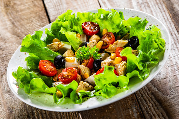 Caesar salad white plate on wooden table