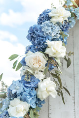Close-up decoration of fresh blue hydrangeas and white peony roses at a wedding or other event. Decoration with flowers.