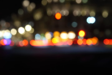 Blurred night city traffic lights. Abstract black background with bokeh effect..