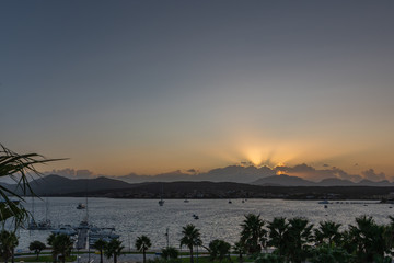 Panoramic view of the sun at sunset on the background of the mountains and the sea