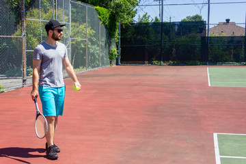 young guy player on a tennis court during the summer in Gatineau, Quebec, Canada © Nataliia