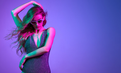 High Fashion. Party girl with pink neon hairstyle dance. Young shapely woman in Colorful uv Light....