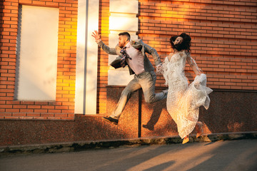 Caucasian romantic young couple celebrating marriage in city. Tender bride and groom on modern...