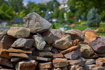 Big pile of rocks and stones in the park. Summer time.