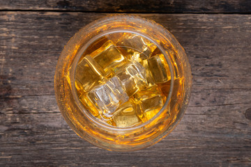 Glass with whiskey on wooden table. Top view.