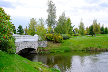 Autumn landscape. A stone bridge over a lake in a park.