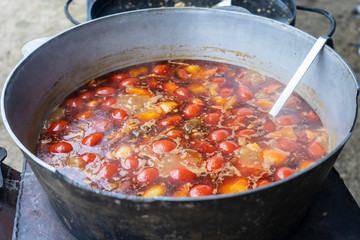 Red tomato soup in cauldron for sell in street food market, Ukraine, closeup